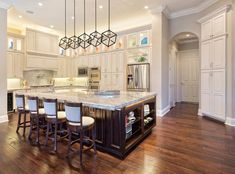 a large kitchen with an island in the middle and lots of stools around it