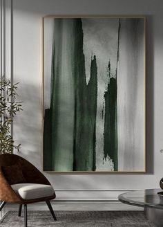 an abstract painting hangs on the wall next to a chair and coffee table in a modern living room