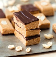 peanut butter bars stacked on top of each other with chocolate and cashews around them