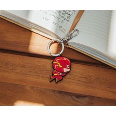 a wooden table with a book and a keychain that has a cartoon character on it