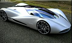 a silver sports car parked on top of a gravel road