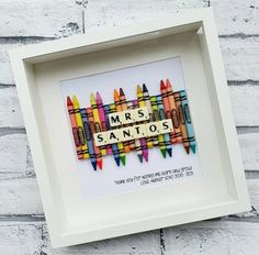 a white frame with some crayons in it and the words, mrs sanyos