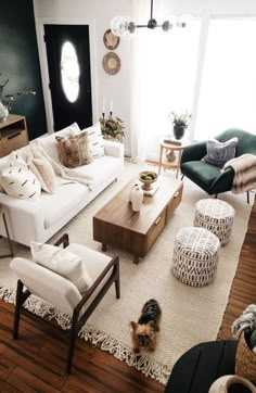 a living room filled with furniture and a dog on the floor in front of it