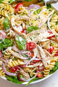 a white bowl filled with pasta salad on top of a table