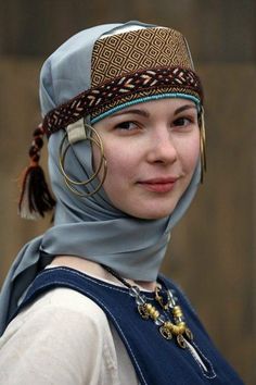 a young woman wearing a headscarf and hoop earrings