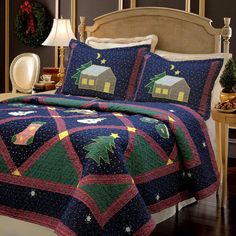 a bed with a christmas quilt on it