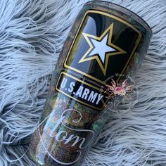 the army glitter tumbler is laying on top of some furry fur and has a star on it