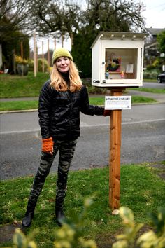 a woman standing next to a mail box