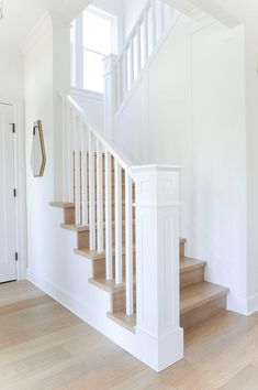 a white staircase with wooden handrails in a house