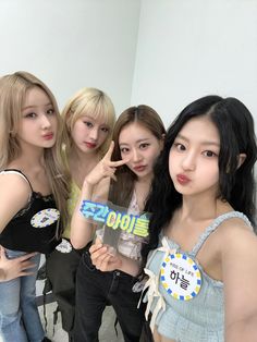 four girls posing for the camera with one holding up a sign