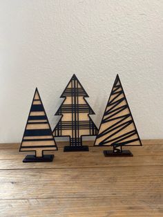 three small wooden trees sitting on top of a table