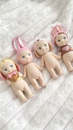 five little dolls are laying on a white blanket