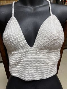 This top is made from cotton yarn.  It is a size medium. Chic Cotton V-neck Halter Top, White Knit V-neck Crop Top, Fitted Cropped Knit Top, Spring Cotton Cropped Crop Top, Trendy Fitted Cotton Knit Top, Trendy Cotton Crochet Crop Top, White Crochet Cotton Halter Top, Trendy Fitted White Crochet Top, Stretch Cotton Cropped Knit Top