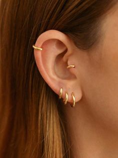 a woman wearing gold ear piercings