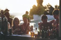 a group of people sitting at a table with bottles