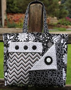 a black and white handbag sitting on top of a wooden bench