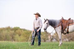 a man standing next to a horse in a field