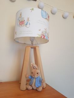 a lamp that is sitting on top of a wooden table next to a stuffed animal