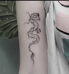 a black and white photo of a dragon tattoo on the left upper half of the arm