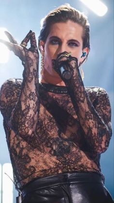 a woman in black lace top holding a microphone