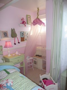 a child's bedroom with pink walls and green curtains