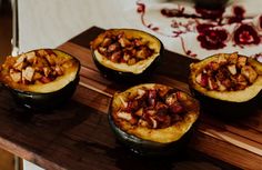 four stuffed acorns sitting on top of a wooden cutting board