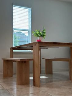 a wooden table and two benches in front of a window