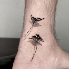 a small tattoo on the ankle of a man's foot with two birds sitting on it