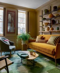 a living room filled with furniture and lots of shelves on the wall next to a window