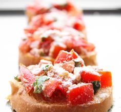 several pieces of bread with various toppings on them sitting on a white table top