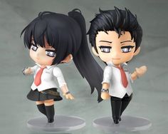 two anime figurines, one with black hair and the other wearing a red tie