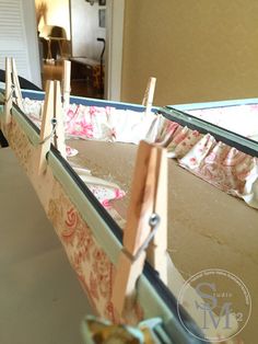 an empty baby crib with clothes hanging from it