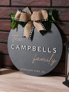 a sign that says the campbells family on it next to a lamp and lantern