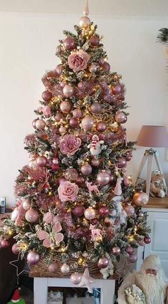 a pink christmas tree decorated with ornaments and lights