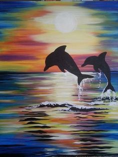 two dolphins jumping out of the water at sunset