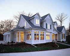 a large white house sitting on top of a lush green field