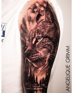 a man's arm with a wolf tattoo on it, and trees in the background