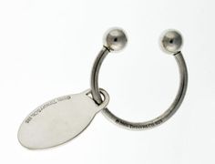 a metal hook with two balls attached to it's end and a tag hanging from the side