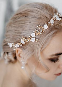 a woman wearing a gold headpiece with flowers and pearls on the top of it