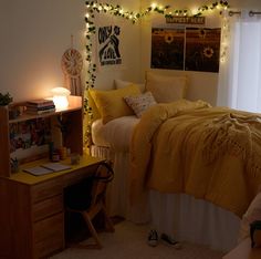 a bedroom with lights strung from the ceiling and yellow comforter on top of it