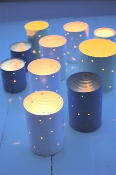 some blue and yellow candles are on the ground with stars around them, as if they were made out of tin cans