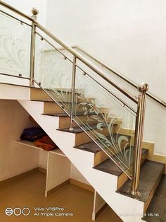 a set of stairs leading up to a second floor with glass railing and handrails