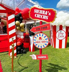 a carnival booth with red and white striped tents, popcorn buckets, and signs