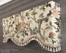 the curtain is hanging on the wall with tassels and flowers painted on it