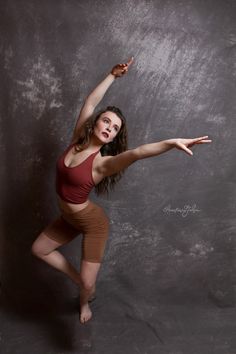 a woman is posing for a photo with her arms outstretched