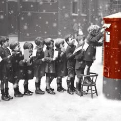 a group of children standing next to each other near a trash can on the street