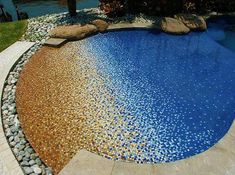 a swimming pool with rocks and stones around it