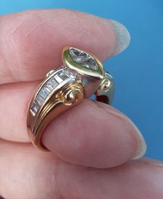 a hand holding a gold and diamond ring