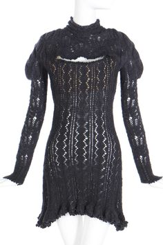 a mannequin wearing a black knitted dress with long sleeves and an open back