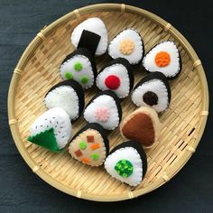 sushi rolls are arranged in a basket on a black tablecloth with bamboo trimmings